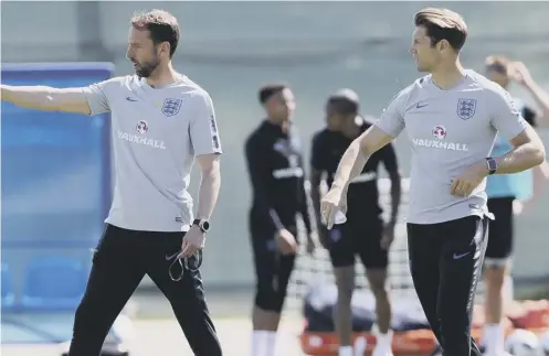  ??  ?? 0 England manager Gareth Southgate, left, and striker coach Allan Russell during training at the Spartak Zelenogors­k Stadium.