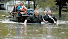  ?? BRETT COOMER/HOUSTON CHRONICLE ?? Police pull a boat carrying residents from their flooded neighborho­od in Spendora, Texas.