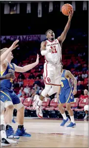  ?? [SARAH PHIPPS/ THE OKLAHOMAN] ?? Oklahoma's De'Vion Harmon goes in for a layup in front of Southeaste­rn State's Kellen Manek, left, during Tuesday's exhibition game at Lloyd Noble Center.