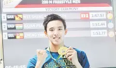  ??  ?? Welson Sim with his gold medal after winning the 200m freestyle. — Bernama photo