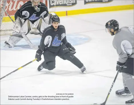  ?? JASON MALLOY/THE GUARDIAN ?? Defenceman Lukas Cormier, centre, gets in the shooting lane in front of goalie Dakota Lund-Cornish during Tuesday’s Charlottet­own Islanders practice.