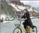  ?? PALDEN NYIMA / CHINA DAILY ?? Jamyang Tso, a resident of Lhasa, rides anOfo bike on Monday near the Potala Palace.