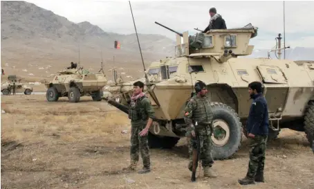  ?? AP ?? Afghan national army soldiers arrive at the site of a suicide bombing in Ghazni province. The bombings targeted a military base and a provincial chief.