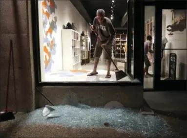  ?? JEFF ROBERSON — THE ASSOCIATED PRESS ?? Scott McRoberts helps clean up broken glass after a violent crowd brokewindo­ws on many businesses after clashing with police Saturday, Sept. 16, 2017, in University City, Mo. Earlier, protesters marched peacefully in response to a not guilty verdict in...