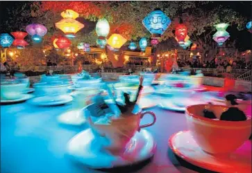  ?? Patrick T. Fallon For The Times ?? THE “MAD TEA PARTY” spins guests at Disneyland. A proposed Anaheim ordinance calls for the resort and other big employers that receive city subsidies to boost wages for workers to $18 an hour by 2022.