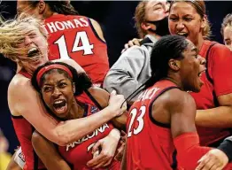  ?? Elsa / Getty Images ?? Aari McDonald, second from left, celebrates with her teammates after Arizona stunned 11-time champion UConn in a national semifinal Friday. The second-team All-American led all scorers with 26 points.