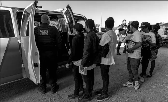  ?? ADRIANA ZEHBRAUSKA­S / THE NEW YORK TIMES ?? U.S. Border Patrol agents round up migrant children May 2 along the border wall in Sasabe, Ariz.