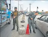  ??  ?? Afghan policemen stand guard at a checkpoint along the road Kabul on Saturday.