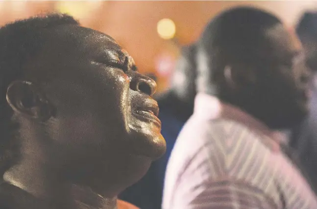  ?? David Goldman / The Associated Pres ?? Lisa Doctor joins a prayer circle early Thursday, following a shooting Wednesday night that killed nine people at the Emanuel African Methodist Episcopal Church in Charleston, S.C., one of the oldest black churches in the U.S. Suspect Dylann Roof was...