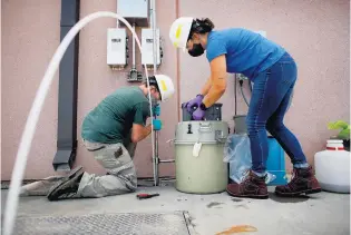  ?? STEPHEN M. KATZ/STAFF ?? David Keeling, technical services specialist, left, and Kat Yetka, water quality specialist, take samples of wastewater for COVID-19 testing at the sanitation district’s Virginia Initiative Treatment Plant on Thursday.