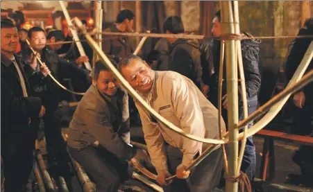  ?? ZHANG ZHISHENG / FOR CHINA DAILY ?? Villagers work on the body of the dry dragon boat, a local intangible cultural heritage in Xiaojiafan­g town, Shaowu city, Fujian province.
