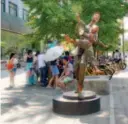  ??  ?? A bronze sculpture of a man holding a boy.