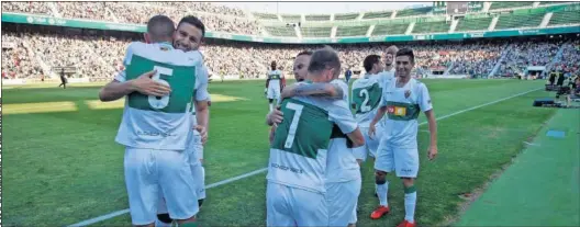  ??  ?? ALEGRÍA. Los jugadores del Elche se abrazan tras el pitido final en el Martínez Valero delante de los 20.164 espectador­es que estaban allí presentes.