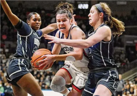  ?? Jessica Hill/Associated Press ?? UConn’s Lou Lopez Sénéchal, center, drives to the basket as Butler’s Rachel McLimore, right, defends in the first half on Saturday.