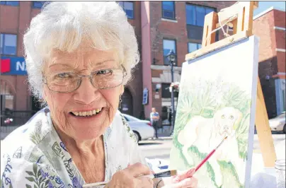  ?? MILLICENT MCKAY/JOURNAL PIONEER ?? Doreen Huestis and her painting of a golden retriever she was working on during Wednesday’s Arts in Motion event on Water Street.