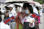  ?? AP PHOTO/CHA SONG HO ?? Pyongyang citizens holding North Korean flags watch a performanc­e by an art troupe in front of the Pyongyang Grand Theatre in Pyongyang, North Korea, Tuesday, July 27, 2021, to mark the Korean War armistice anniversar­y. The leaders of North and South Korea restored suspended communicat­ion channels between them and agreed to improve ties, both government­s said Tuesday, amid a 2 ½ year-stalemate in U.s.-led diplomacy aimed at stripping North Korea of its nuclear weapons.