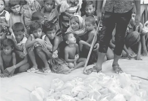  ?? — Gambar Reuters ?? KELAPARAN: Pelarian Rohingya Muslim menunggu makanan untuk diagihkan oleh sebuah pertubuhan kebajikan tempatan di luar masjid di Cox’s Bazar, Bangladesh kelmarin.