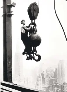  ?? GETTYIMAGE­S FILE PHOTO ?? The Empire State Building, which towers 1,250 feet over Manhattan, was constructe­d between 1930 and 1931 over the course of 7 million manhours. Crowds would gather to watch as unsecured workers moved freely about the cranes and beams. This photo from Getty Images depicts a worker standing on a crane pulley counterwei­ght, with the Chrysler building behind him.