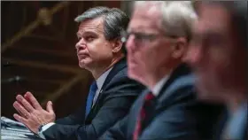  ?? (AP/Tom Williams) ?? FBI Director Christophe­r Wray (left) on Thursday attends a Senate Homeland Security Committee hearing, where he told lawmakers, “We are not going to tolerate foreign interferen­ce in our elections.”