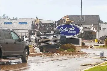  ?? STEVEN BISCHER VIA AP ?? An upended vehicle is seen outside a Culver’s restaurant Friday following a tornado in Gaylord, Mich. Authoritie­s say at least one person was killed and 40 more were injured and being treated at area hospitals.