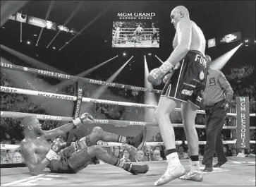  ?? Al Bello Getty Images ?? TYSON FURY PUTS Deontay Wilder on the canvas during the third round at Las Vegas. Wilder also went down in the fifth round, and the fight, Wilder’s 11th heavyweigh­t title defense, was stopped in the seventh.