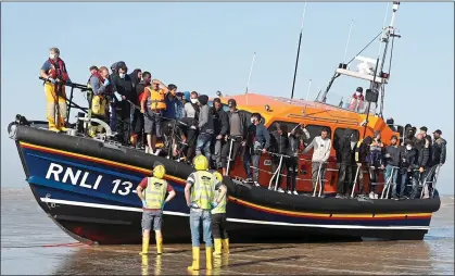  ?? ?? RESCUED: But migrants such as these brought ashore in Kent last week face only rudimentar­y checks on their age