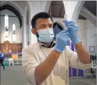  ?? Kirsty Wiggleswor­th / Associated Press ?? Pharmacist Rajan Shah prepares a syringe of the AstraZenec­a vaccine at St John’s Church in Ealing, London, on March 16.