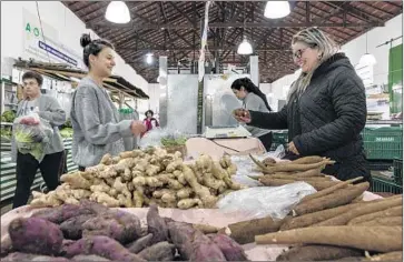  ?? Photograph­s by Gui Christ For The Times ?? THERE IS plenty of demand for organic produce. At right, Monica dos Santos sells root vegetables at an organic products fair at Sao Paulo’s Agua Branca Park. The vegetables were grown on her father’s farm, below.