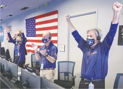  ?? BILL INGALLS / NASA / AFP VIA GETTY IMAGES ?? Members of NASA's Perseveran­ce rover team celebrate in mission control Thursday after receiving confirmati­on the spacecraft successful­ly
touched down on Mars within its target zone inside Jezero Crater, which is the site of a long-vanished Martian lake bed.