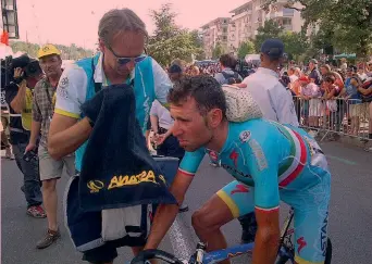  ??  ?? Il massaggiat­ore Michele Pallini subito dopo l’arrivo piazza la borsa del ghiaccio sulla nuca di Vincenzo Nibali