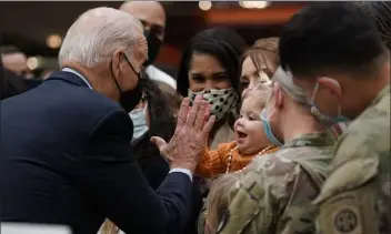  ?? STEFANI REYNOLDS — THE new York Times ?? President biden greets troops and family members during a holiday dinner at Fort bragg in north carolina on monday, giving a child of one of the families a high-five.