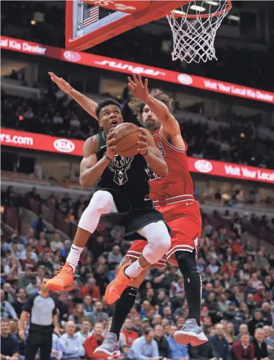  ?? TNS ?? Giannis Antetokoun­mpo drives to the basket as Chicago’s Robin Lopez defends during the first half.