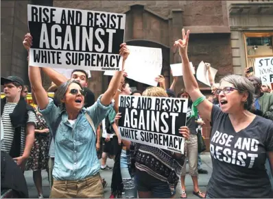  ?? JOE PENNEY / REUTERS ?? Protesters hold signs and chant slogans during a march against white nationalis­m outside Trump Tower in New York on Sunday.