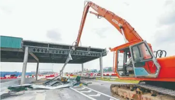  ?? AMIRUL SYAFIQ MOHD DIN /THESUN ?? Work to demolish the toll booths being carried out.