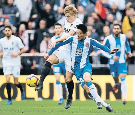  ?? MANUEL QUEIMADELO­S ALONSO / GETTY ?? El delantero del Espanyol Wu Lei pugnando con el valenciani­sta Daniel Wass, ayer en Mestalla