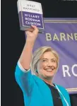  ?? DREW ANGERER/ GETTY IMAGES ?? Hillary Clinton holds a copy of “What Happened” last week.
|