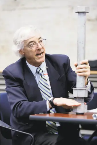  ?? Connor Radnovich / The Chronicle ?? Brian Maroney, the chief engineer of the Bay Bridge project, uses a large bolt to explain safety measures at a meeting of Caltrans’ Toll Bridge Program Oversight Committee in Sacramento.