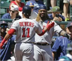  ?? TED S. WARREN - THE ASSOCIATED PRESS ?? Boston Red Sox’s Rafael Devers (11) is greeted at the plate by Hanley Ramirez, right, after Devers hit a solo home run, his first major-league hit, in the third inning against the Seattle Mariners Wednesday in Seattle.