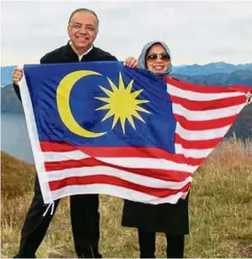  ??  ?? Flag pride: Ameer and his wife Dr Siti Hawa proudly flying the Malaysian flag in Wanaka, New Zealand.