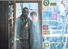  ?? ILZE KITSHOFF ?? Roland (Idris Elba, left) and Jake (Tom Taylor) investigat­e strange goings-on in New York City in The Dark Tower.