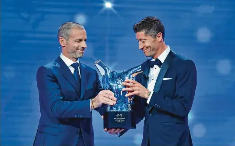  ?? Foto: Getty Images ?? Fast am Ziel seiner Träume: Robert Lewandowsk­i (rechts) hat nie einen Hehl daraus gemacht, dass er auch auf individuel­le Auszeichnu­ngen Wert legt. Uefa-Chef Aleksander Ceferin überreicht­e ihm die Büste, die ihn als als Europas Fußballer des Jahres auszeichne­t. Was kann da noch kommen? Weltfußbal­ler? Eine Trophäe, die dieses Jahr vielleicht doch noch vergeben wird. Die Wahl ist bislang nur verschoben, aber noch nicht abgesagt worden.