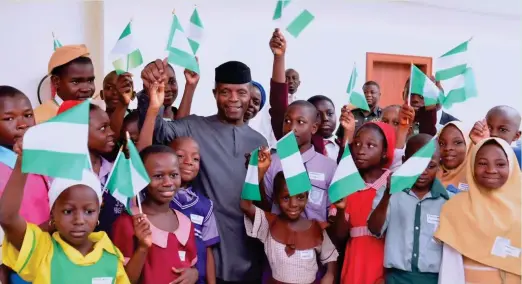  ??  ?? Vice President Yemi Osinbajo (centre) holds up the Nigerian f lag with school children at the State House, Abuja, to commemorat­e 2017 Children’s Day