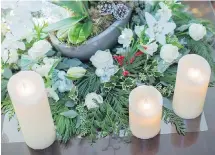  ??  ?? Right: A wreath of greenery, dotted with roses and lilies, decorates the coffee table, along with a trio of candles.