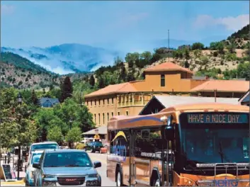  ?? Bob Pearson European Pressphoto Agency ?? SMOKE BILLOWS from the Waldo Canyon fire in the hills west of Manitou Springs, Colo. Hotels in the mountain resort town are near-empty at a time when local shops and bars are usually teeming with people.