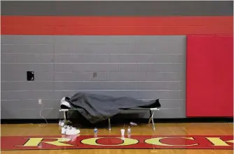  ?? Jessica Phelps/staff photograph­er ?? A man stays under his blanket at an emergency warming shelter on Feb. 17, 2021. The city will open 11 overnight warming centers starting Sunday until Wednesday.