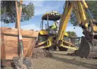  ?? PHOTOS BY MARK HENLE/THE REPUBLIC ?? Above: Jonathon Wells operates a backhoe to dig a hole at Cortez Park in Phoenix. Top: Emmett Boyd, left, and Cesar Chavez, unload trees to plant.