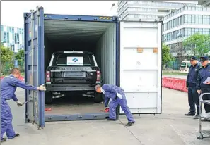  ?? CHEN JIAN / FOR CHINA DAILY ?? Workers unload a car at Chengdu inland port that was shipped from Nuremberg in Germany using a China Railway Express freight service.