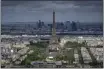  ?? AURELIEN MORISSARD — THE ASSOCIATED PRESS ?? Stands are under constructi­on on the Champ-de-Mars with the Eiffel Tower on Monday in Paris. The Champ-de-Mars will host the Beach Volleyball and Blind Football at the Paris 2024 Olympic and Paralympic Games. Le Defense business district is seen in the background.