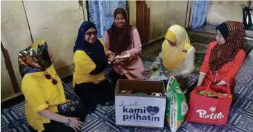  ??  ?? PEMBERIAN barang keperluan harian dan duit raya ceriakan penerima.