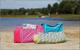  ?? HOLLY RAMER — THE ASSOCIATED PRESS ?? This photo shows three tote-able towels on the beach in Hopkinton, N.H, Beach towels can pull double duty or at least be easier to carry if you add straps to turn them into tote bags.